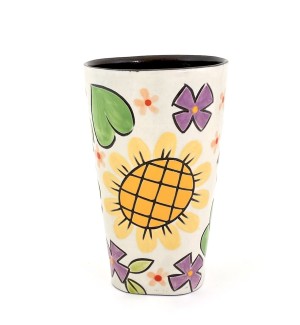 a ceramic tumbler with a white base and illustration of a bouquet of a yellow sunflower, blue forget me nots and orange black eyed Susans.