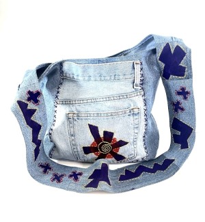 a shoulder bag sewn of blue jean material and painted with graphic design symbols.