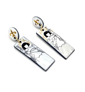 a pair of handmade white ceramic earrings comprised of an oval piece illustrated with a flour de lis and a rectangular drop with a illustration of Joan of Arc.