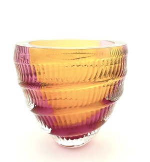 a handblown glass bowl with a ribbed surface and blended color from rose to orange.