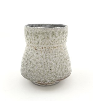a hand thrown ceramic cup with a pebbly white and grey glaze.