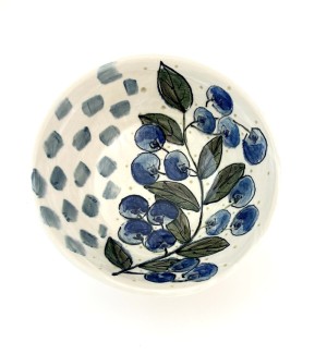 a white ceramic bowl illustrated with blueberries and a cluster of blue squares.