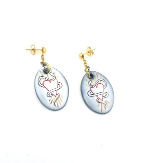 a pair of post style earrings with a short gold chain from which hangs a white oval disc illustrated with a line drawing of a heart intertwined with a serpent..