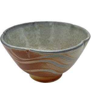 a scalloped-edge bowl with wave patterns in orange and light grey