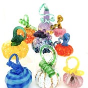 a group of nine glass pumpkins in a variety of shapes and colors.