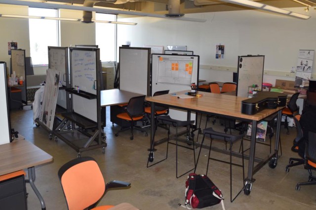 lab space with several tables and chairs, and whiteboards.