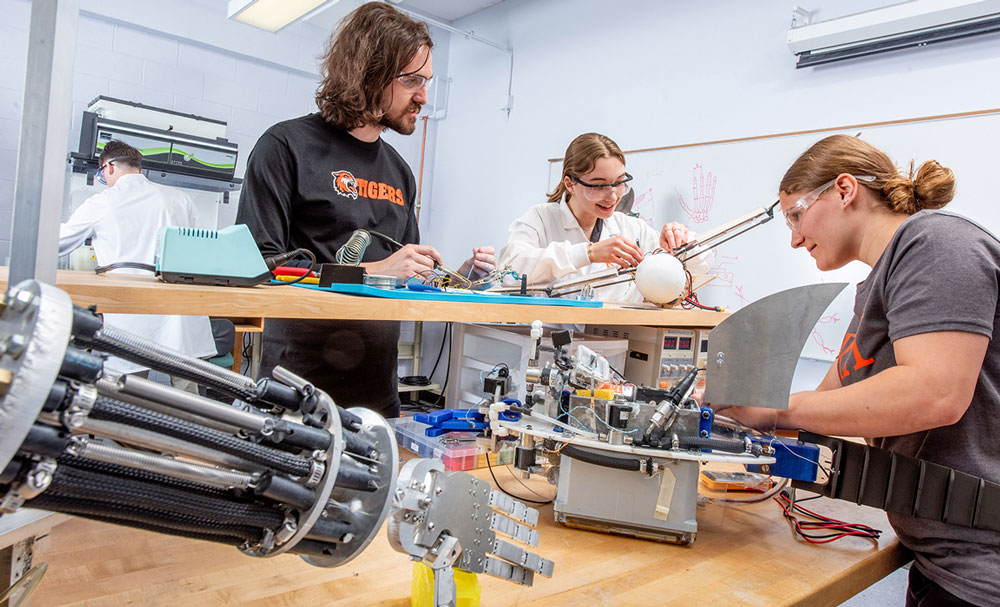 Group of students working together on a workbench. 