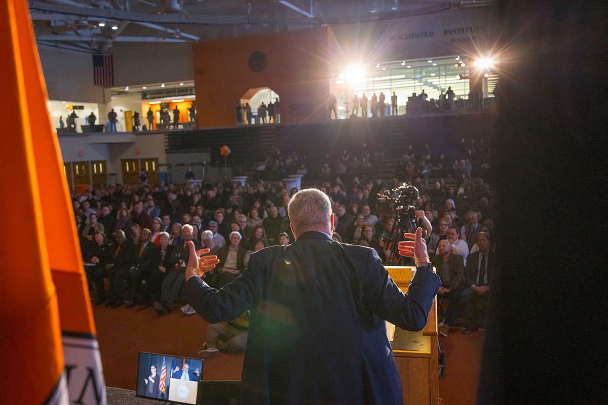 President Sanders stand in front of a large crowd of people.