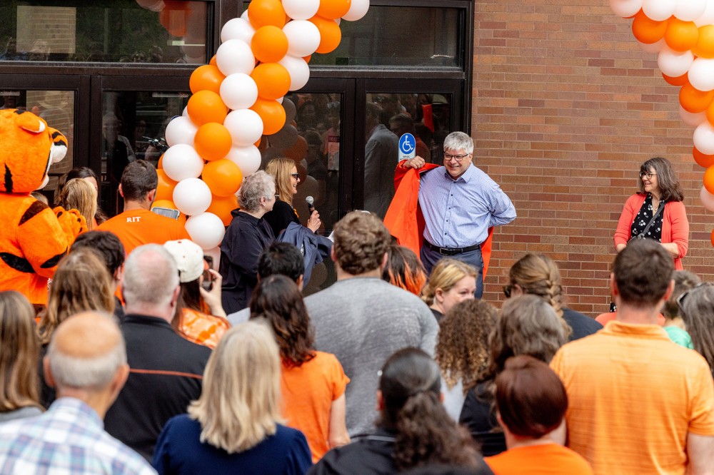 President Sanders puts on an orange blazer.