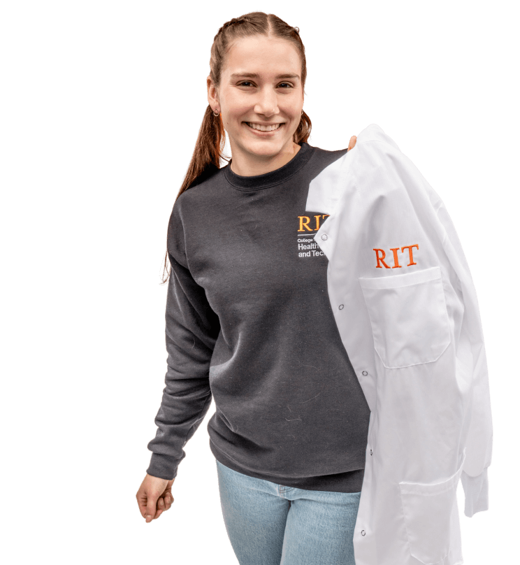 An RIT student smiling while holding an RIT lab coat.
