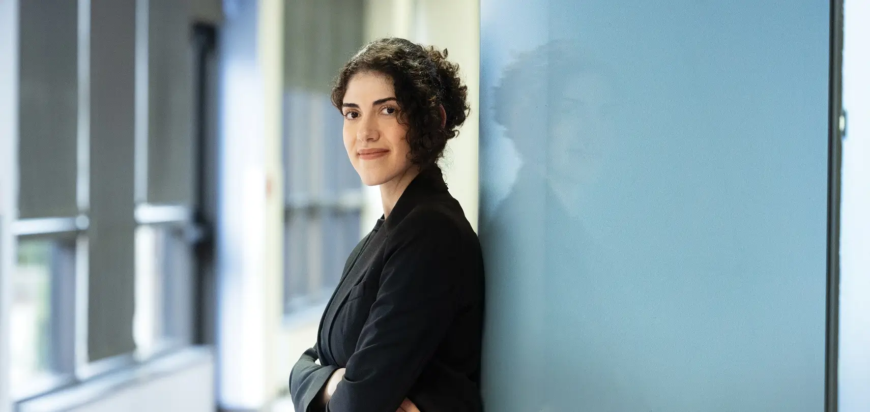 Maryam Toloubidokhti standing against a wall.