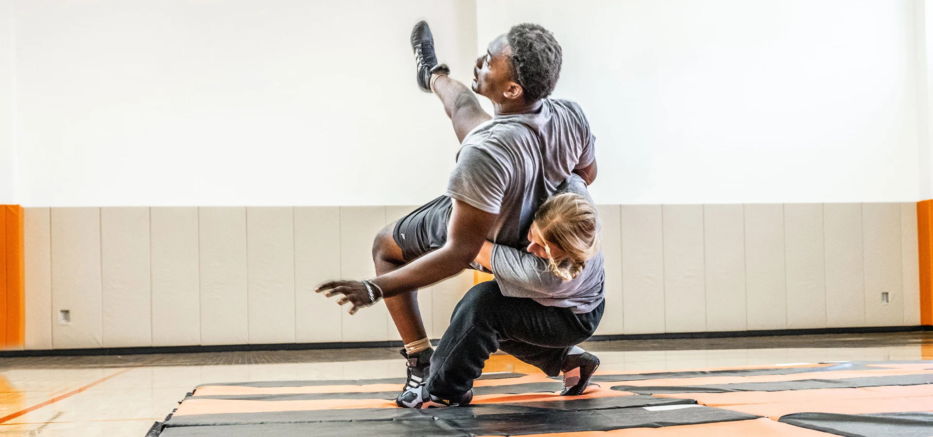 Two wrestlers grappling on a mat