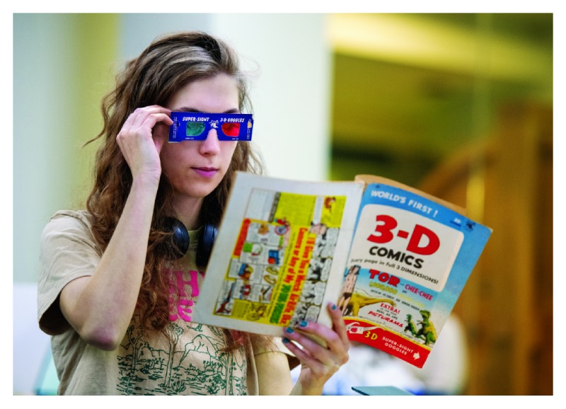 Student looking at a magazine with paper 3d glasses