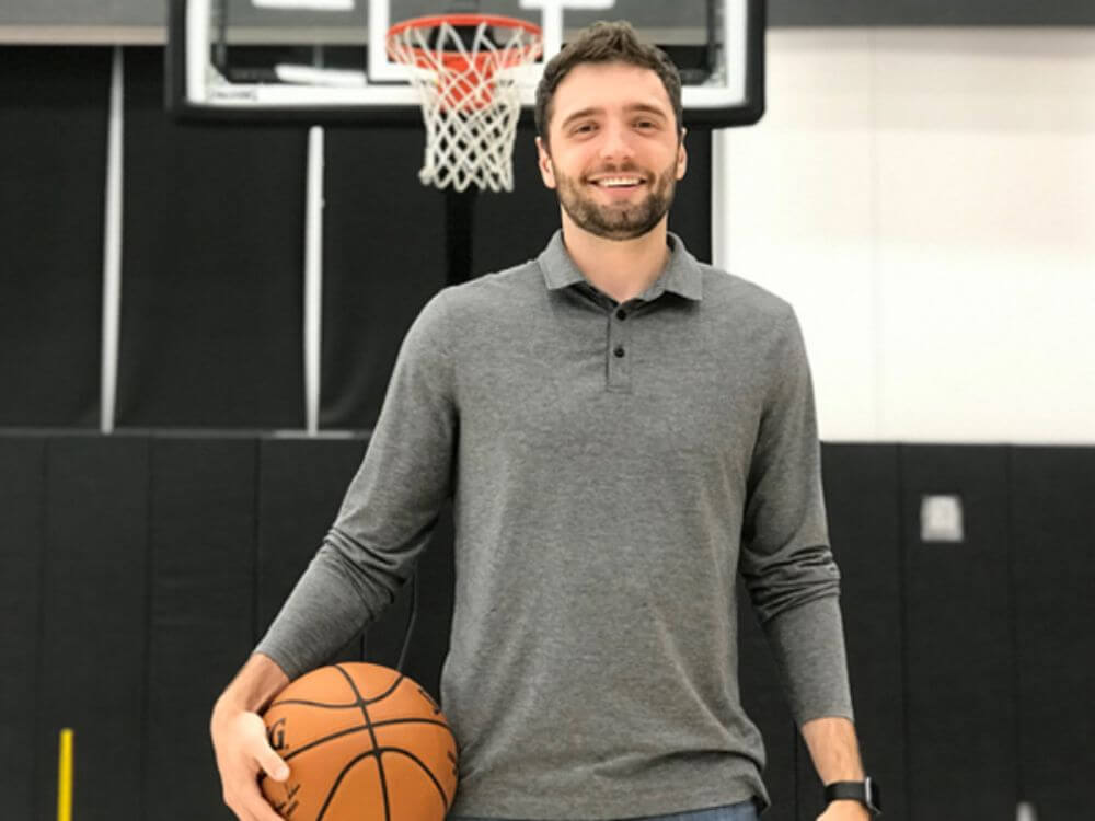 Calvin Floyd smiling and holding a basketball.