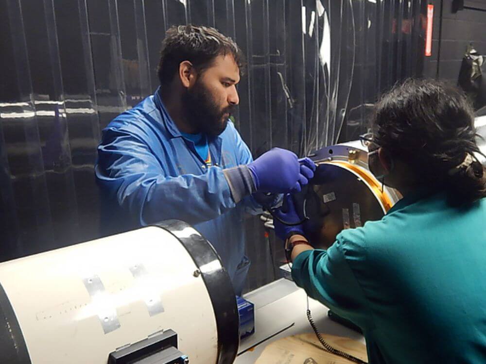 Mike Ortiz and another person assembling a piece of equipment.