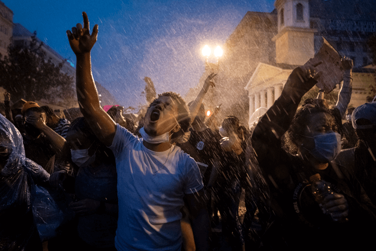 A crowd of protesters marching at night.