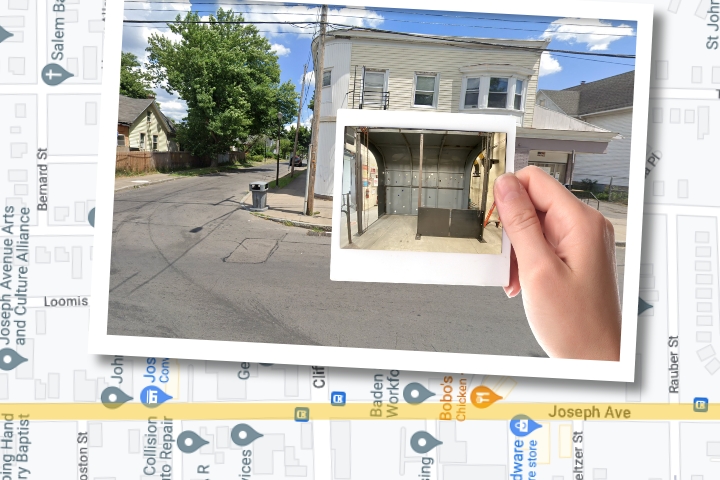 A hand holding a photo in front of a building.