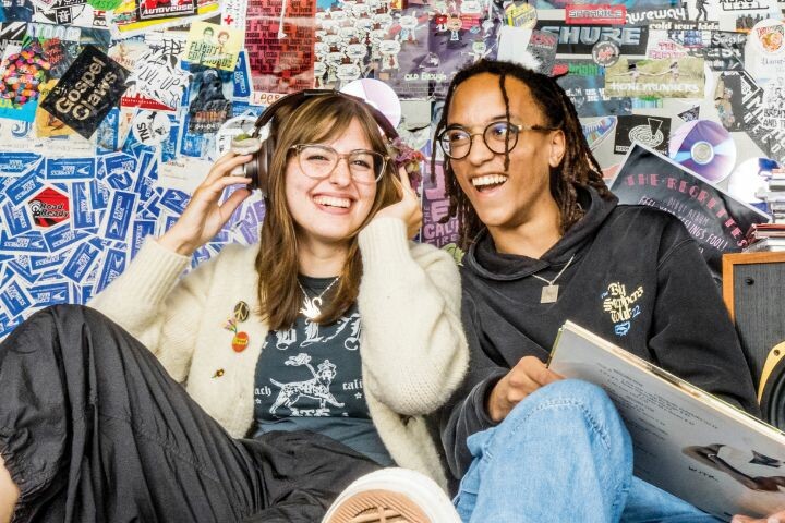 Two students sitting in the WITR broadcasting room.