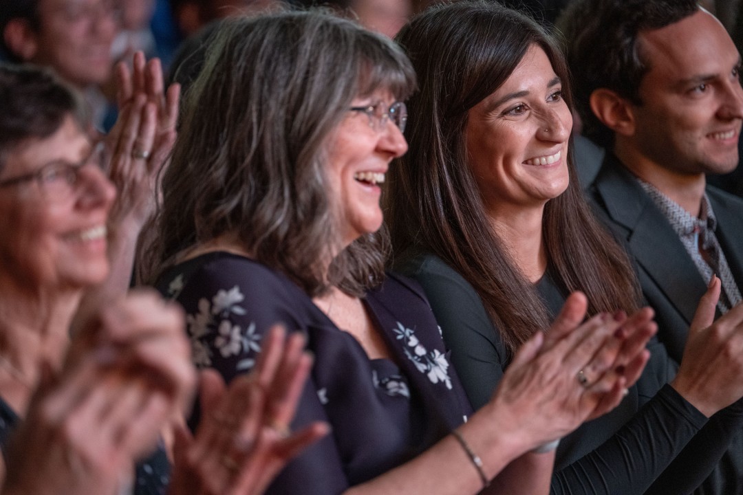 President Sanders's wife and daughter smile and clap enthusiastically during the inauguration ceremony.