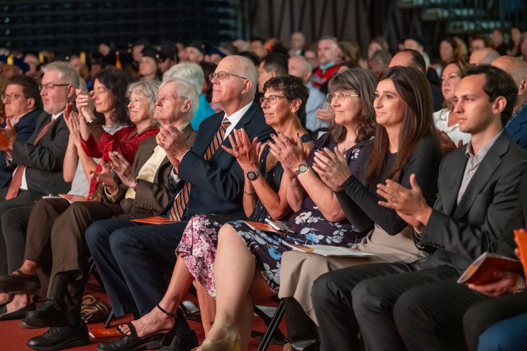 Family and guests, including past R I T presidents Bill Destler and David Munson, seated in the front row applaud together during the inauguration ceremony.