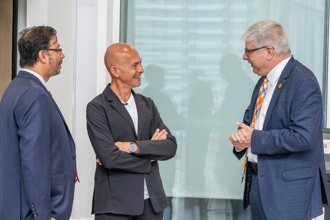 R I T president Sanders talks to two others.