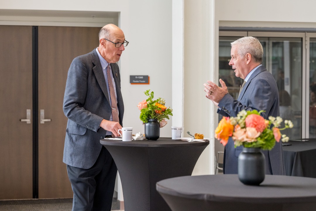 Two people conversing at a reception event.