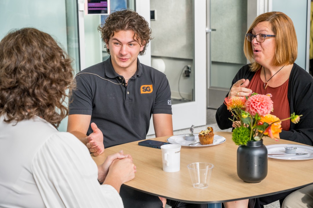 Three people seated having a conversation at a reception.