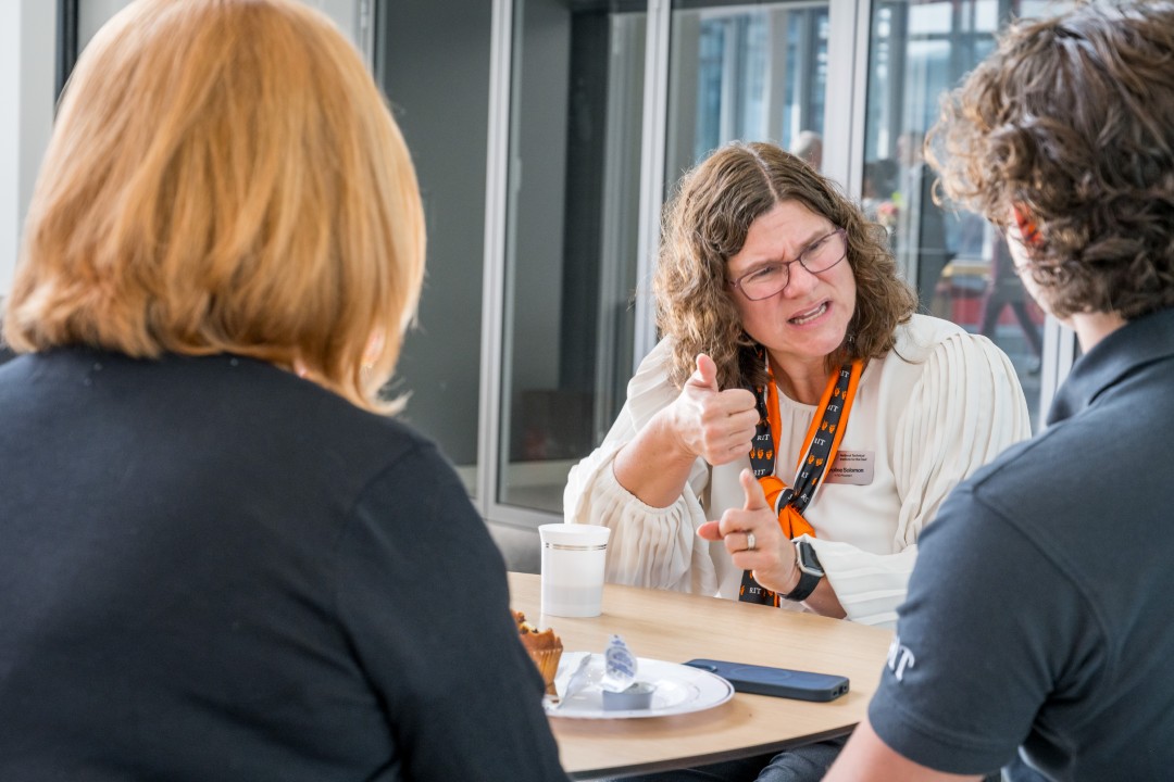 Three people having a converation, with one person using sign language.