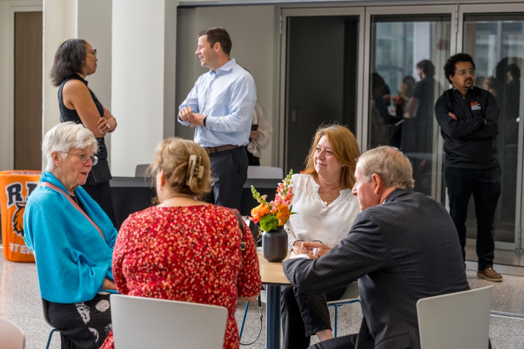 Reception attendees chat in small groups.