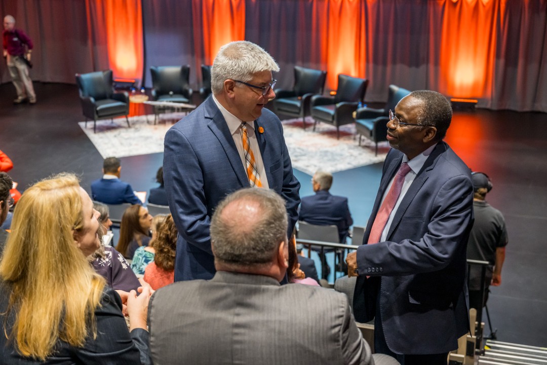 R I T president Sanders talks to a man in the audience.