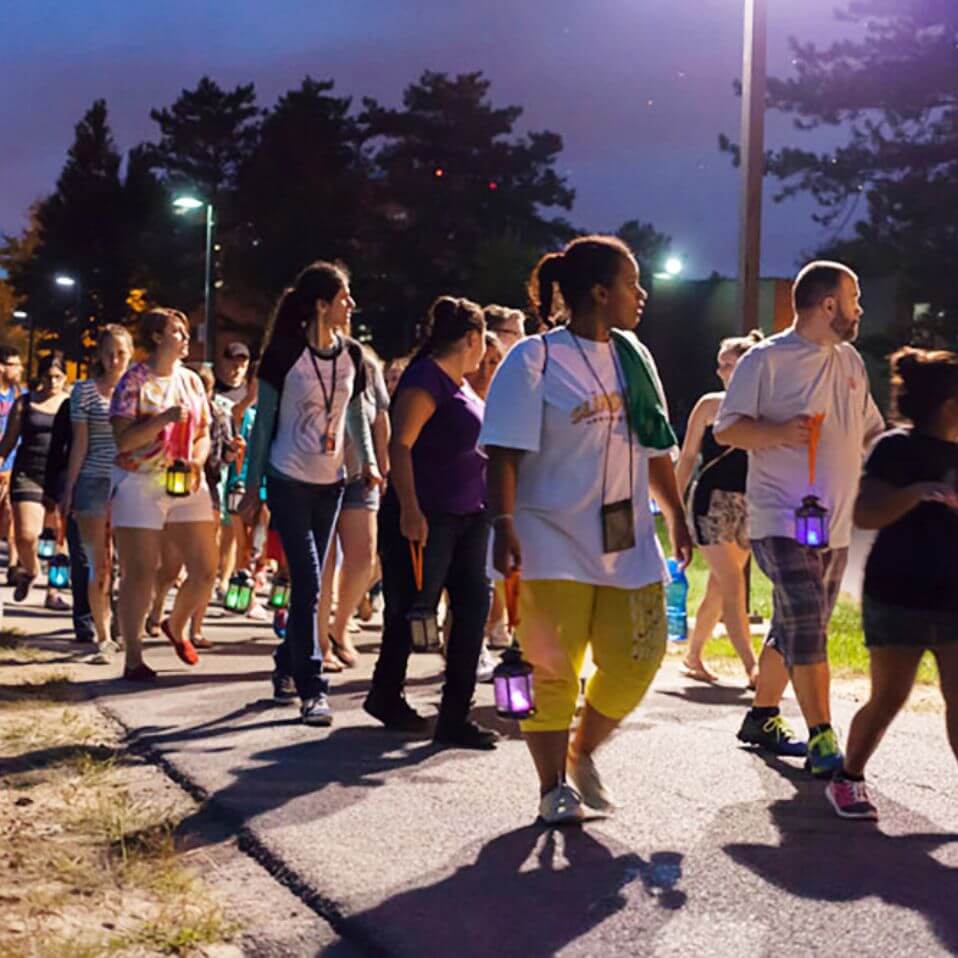 R I T students walking through campus, participating in the Lighting the Way ceremony.