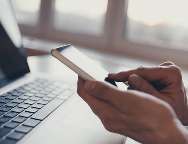A closeup of a pair of hands interacting with a smartphone.