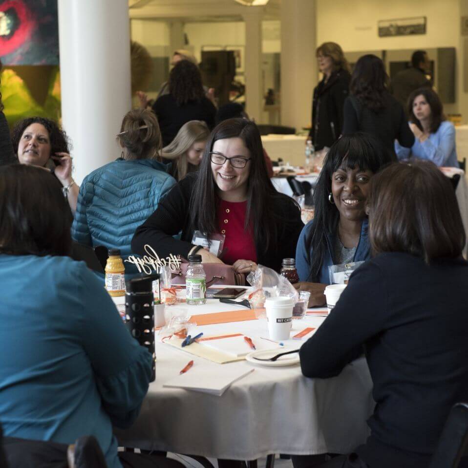 Women sitting at a table during an event.