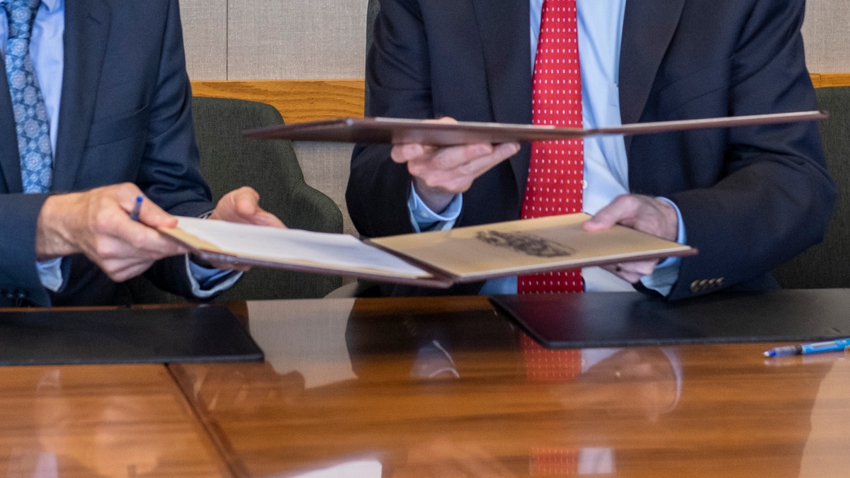 Officials handing paperwork to each other.