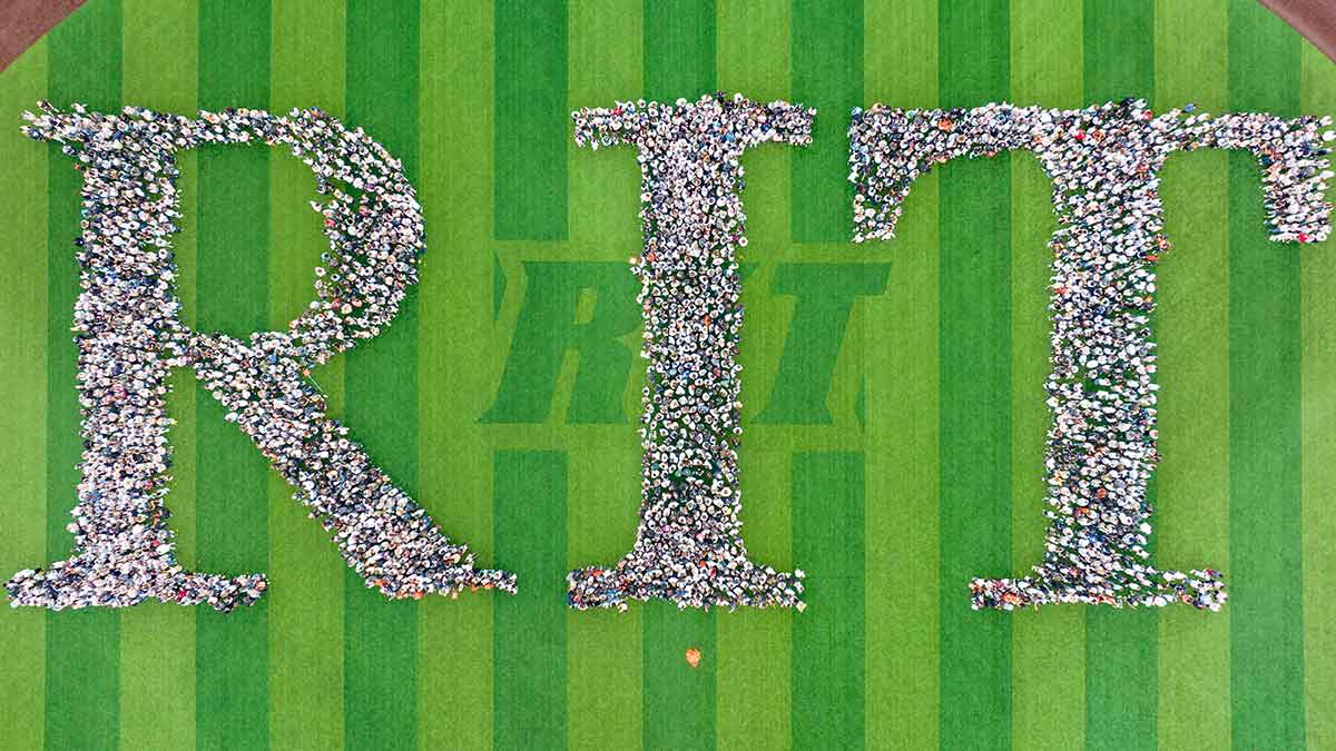 aerial view of the newest class of R I T students arranged on a turf field to spell the letters R I T