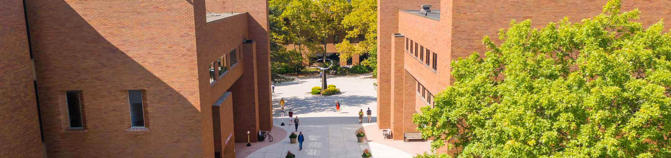 Aerial view of the R I T campus, showing students walking between the Library and Liberal Arts Hall.