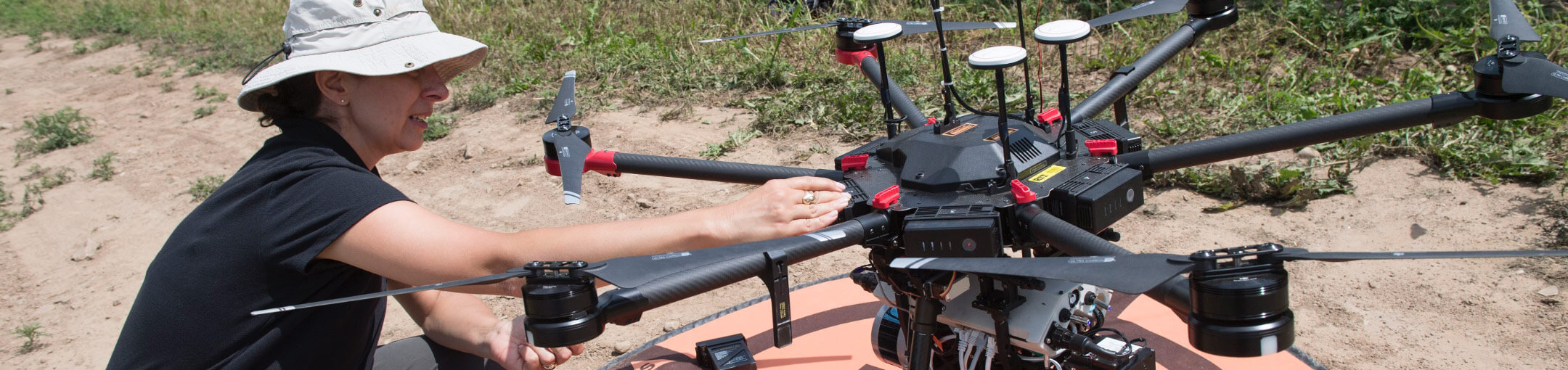 A researcher working on a drone in the field