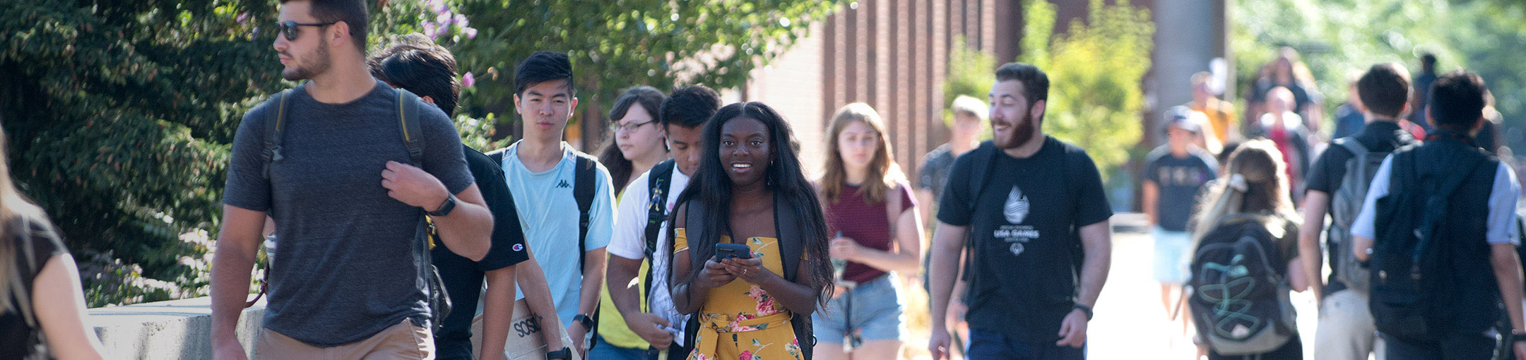A group of students walking down the Quarter Mile on the RIT campus