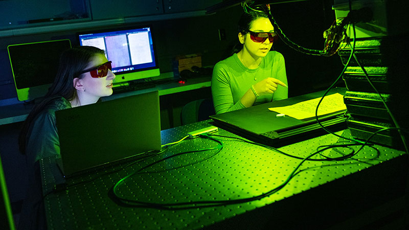 2 students working in a lab with very bright light