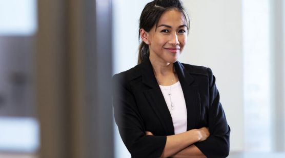 Woman in a suit standing with arms crossed