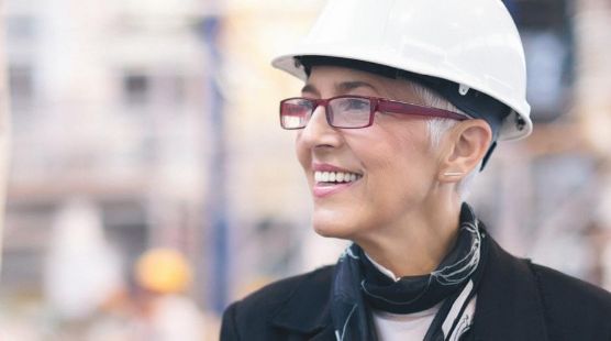 Woman with glasses wearing a hard hat