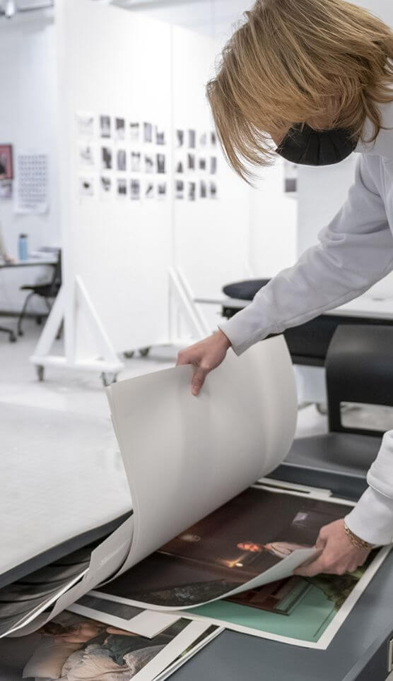 A student looking through photos that have been printed out.