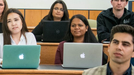 People with laptops sitting in a lecture hall