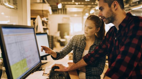 Man and woman pointing to a computer screen