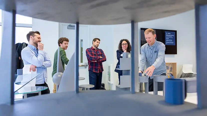 Five people standing together looking at designs.