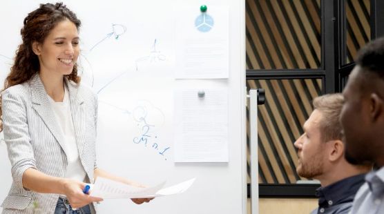 Woman presenting a paper to a group of others