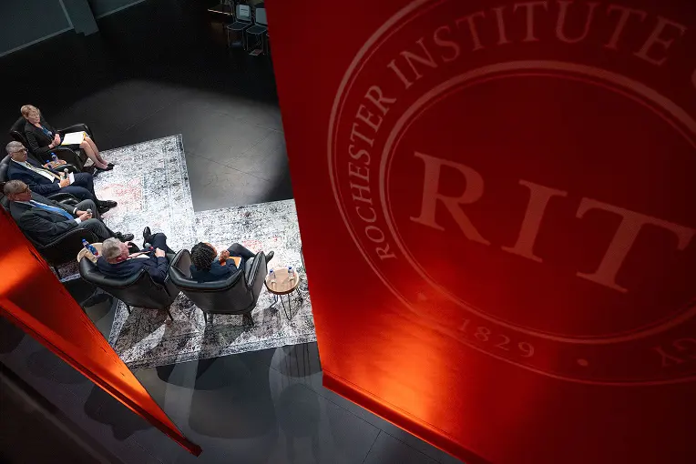 RIT Signage with people sitting underneath