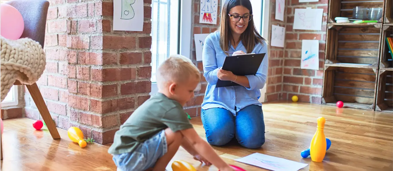 An adult observing a child during playtime.