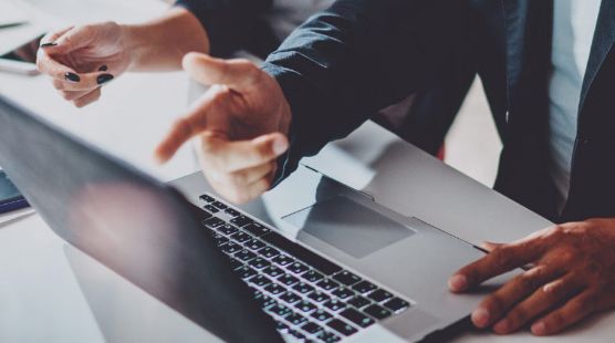 Hands pointing to a laptop