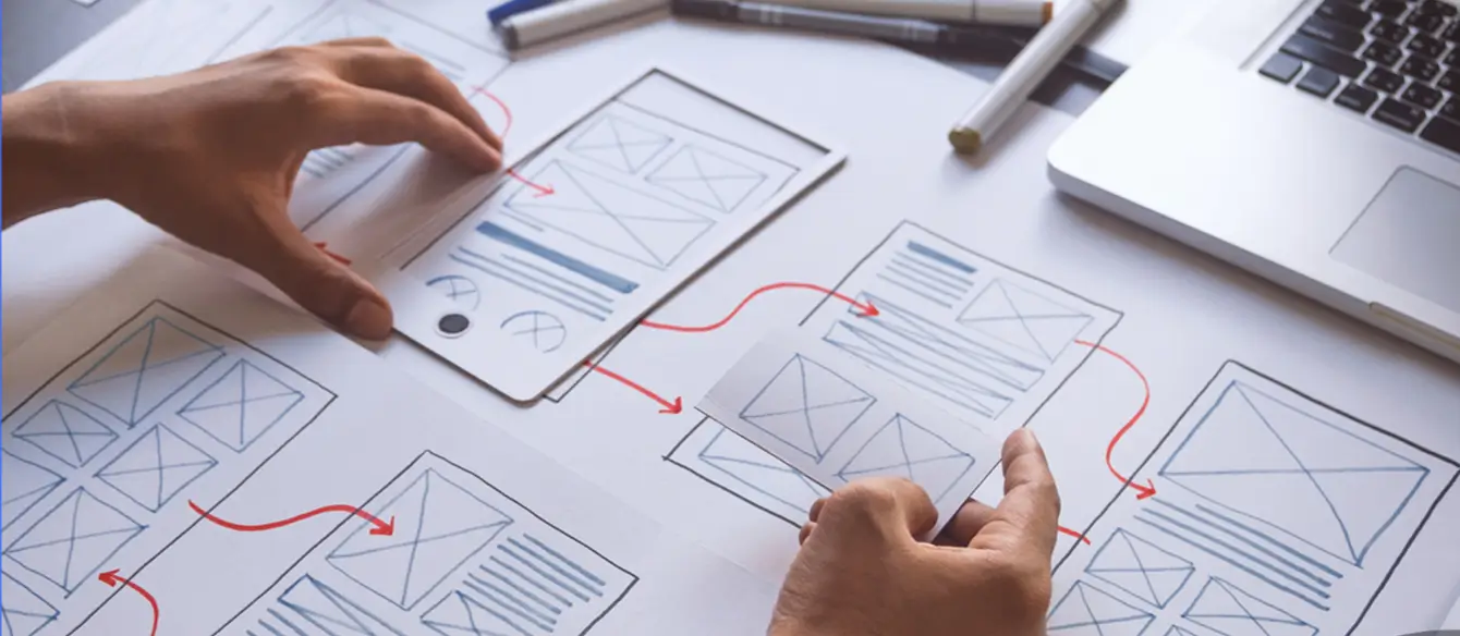 Closeup of a person's hands adjusting a user experience flowchart.